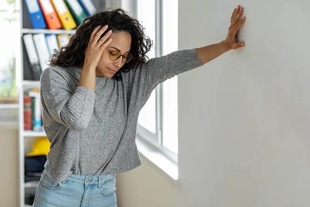 a woman holding her head experiencing a headache