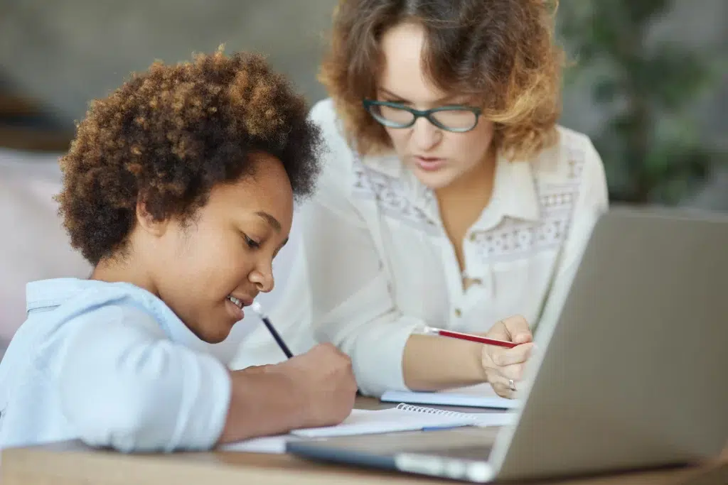 female caregiver helping a young girl with academics