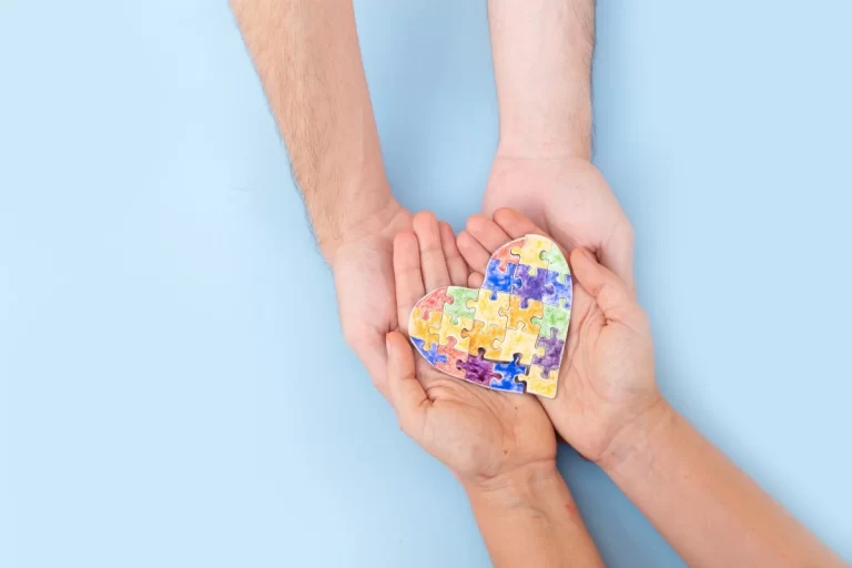 painted puzzled heart held in little hands