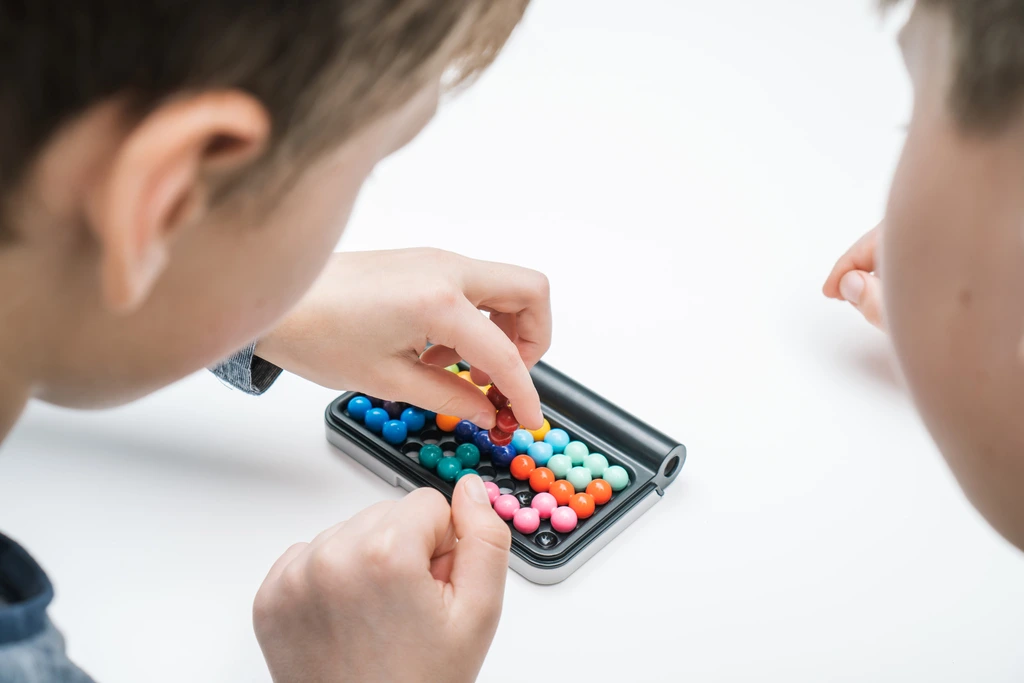 two boys with Asperger syndrome playing with tiny colourful balls