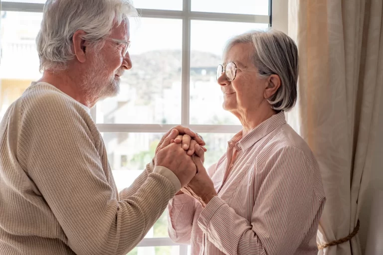 older couple holding hands looking at each other