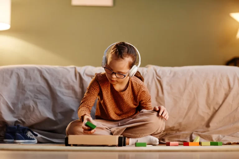 a kid with headphones playing with blocks