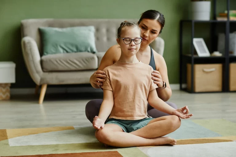 therapist helping a down syndrome girl with proper posture