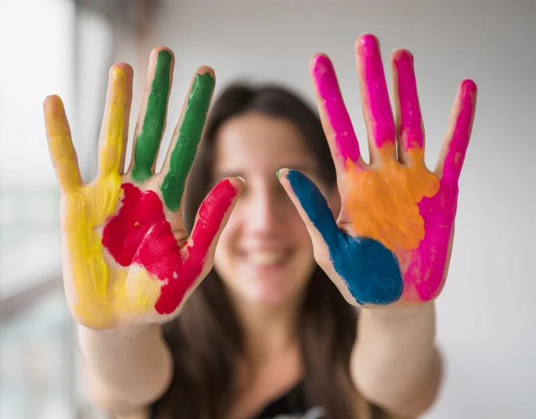 girl with painted hands with rainbow colours