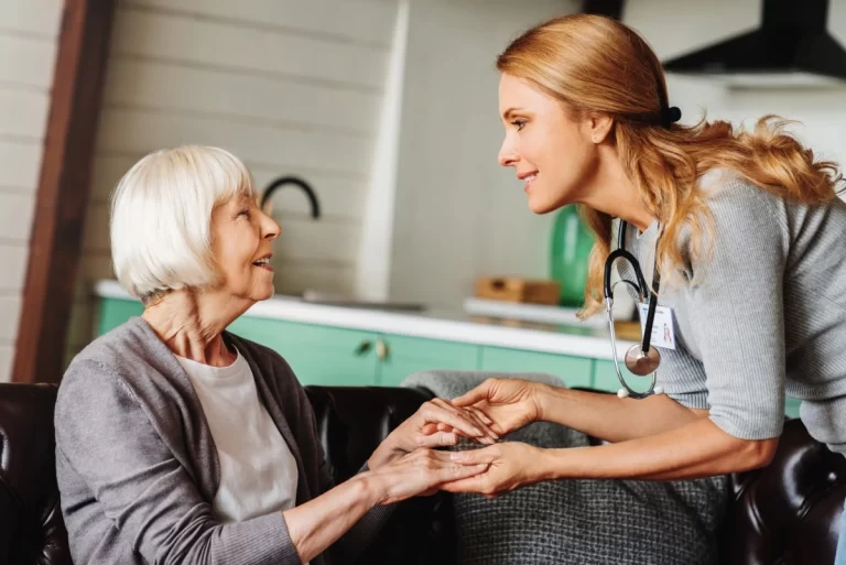 home carer holding hands with elderly lady