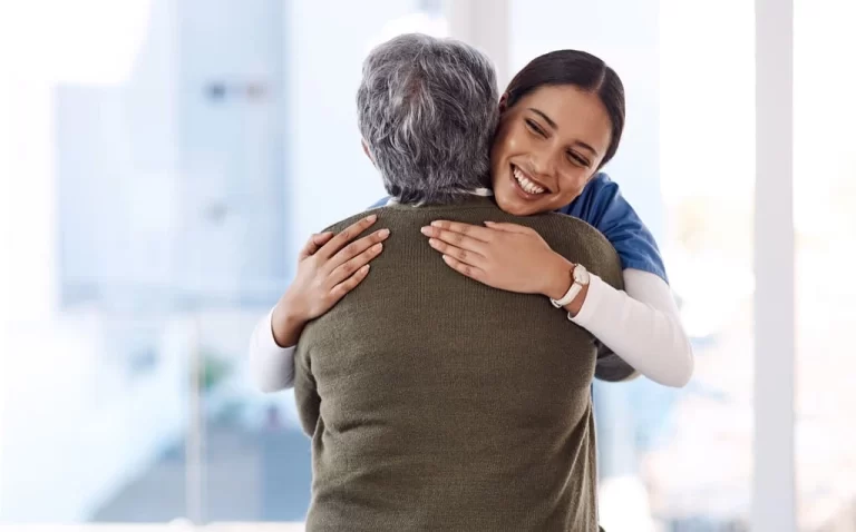 caregiver hugging an elderly lady