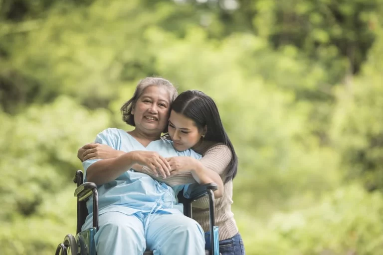 young girl hugging an elderly lady in a wheelchair