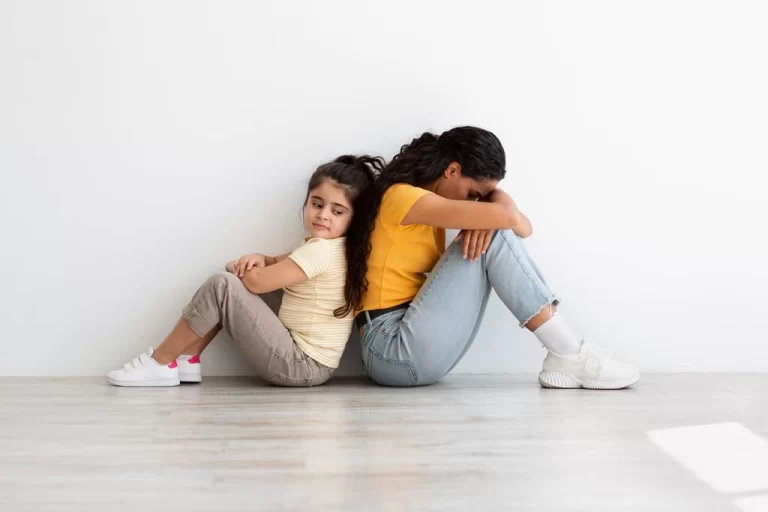 kid with challengig behaviour sitting back-to-back with mother