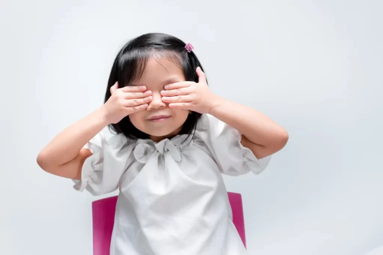 little girl covering her eyes