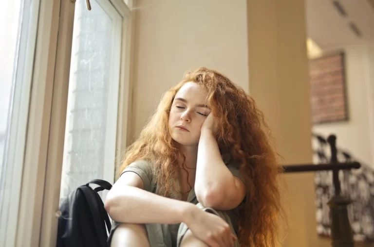 red haired curly girl sitting and thinking