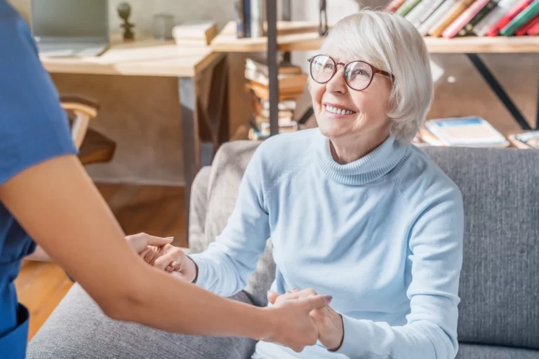 an elderly lady holding hands with a caregiver