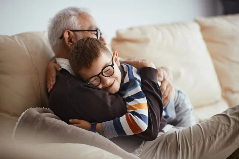 an elderly man hugging his grandchild
