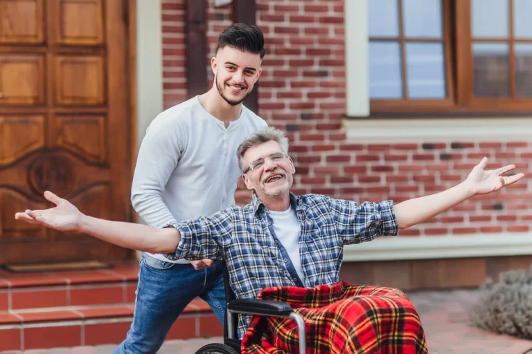 young man helping an elderly man in a wheelchair