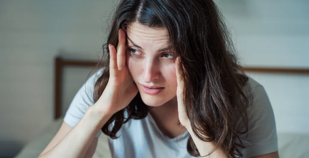 girl holding her face with both hands