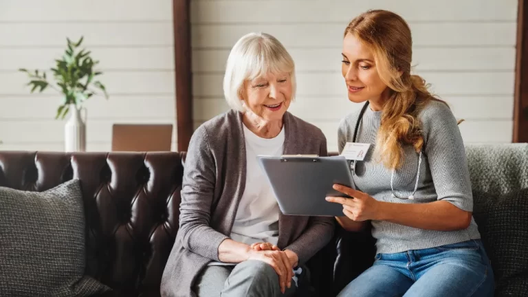 a caregiver showing a chart to an elderly lady