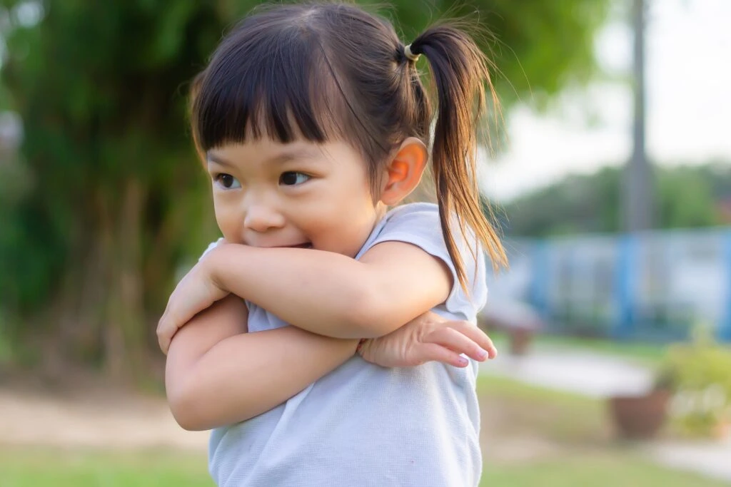 small girl crossing her arms smiling