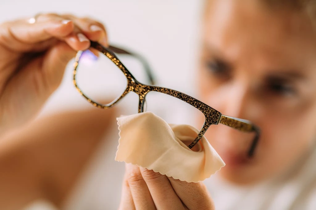 woman cleaning eyeglasses