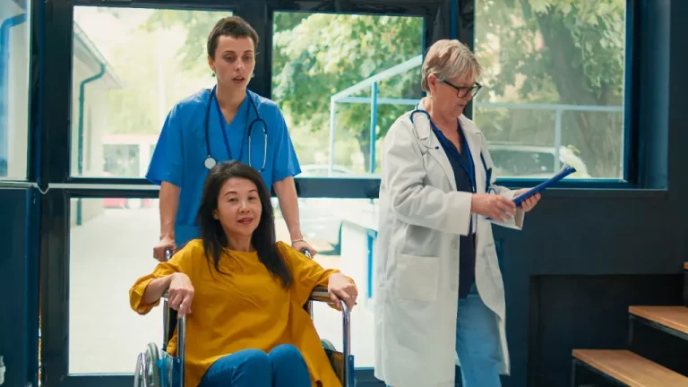 a lady in a wheelchair being pushed by a nurse