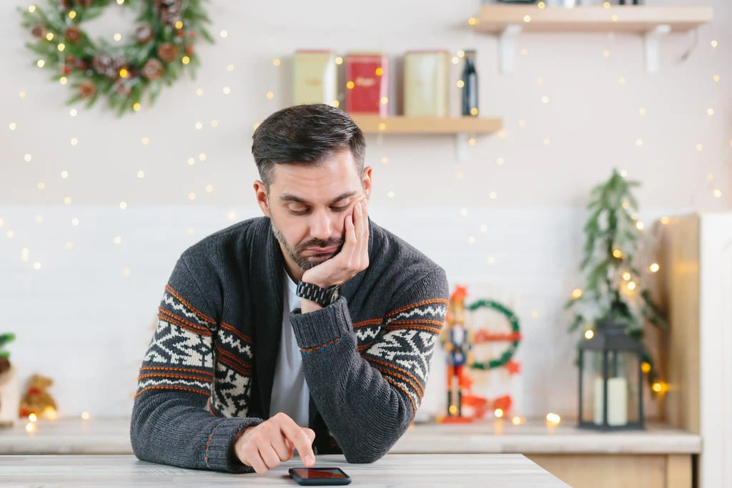 man with anxiety on christmas on his phone