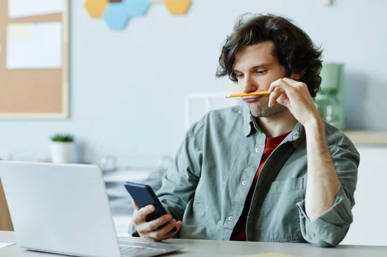 a man looking at his phone and looking bored