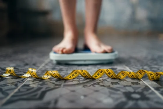 a shot of human legs standing on a scale