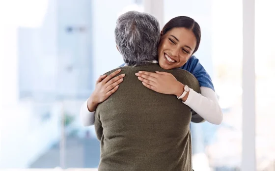 caregiver hugging an elderly lady