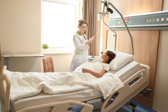 nurse attending a patient in a hospital bed