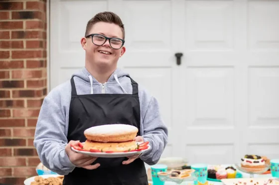 a man with down syndrome holding a cake