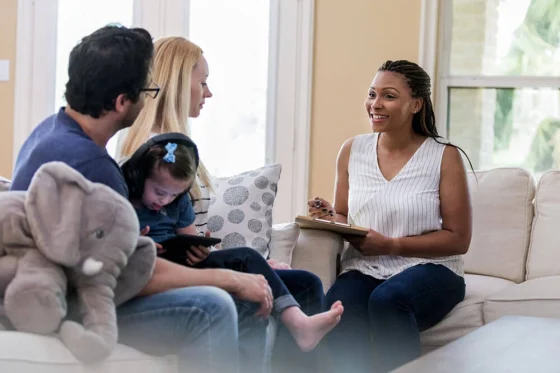 caregiver talking to a dad with his daughter