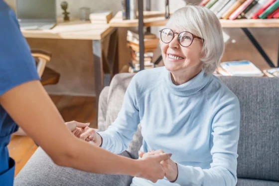 an elderly lady holding hands with a caregiver