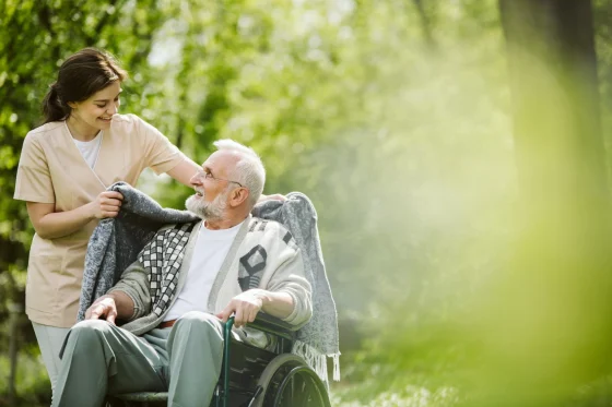 female caregiver taking a man in a wheelchair for a walk
