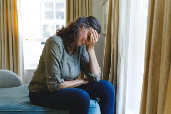 woman holding her head in her hand