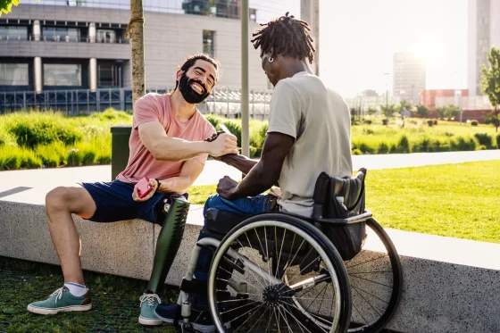 man in a wheelchair saluting his friend