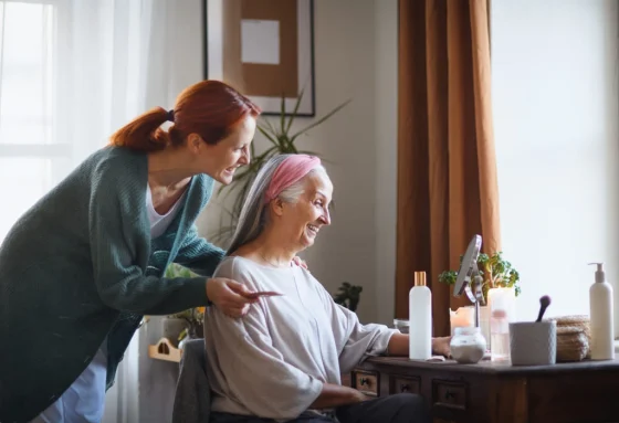 a female support worker combing the hair of an old woman
