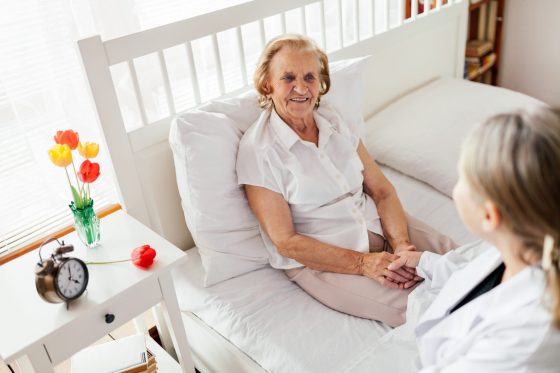 waking night carer talking to an elderly lady in her bed