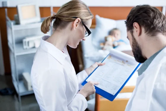 two medical professionals looking at a medical records