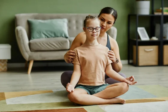 therapist helping a down syndrome girl with proper posture