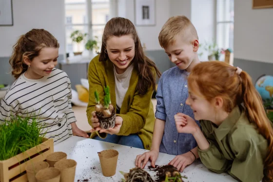 caregiver teaching little children gardening