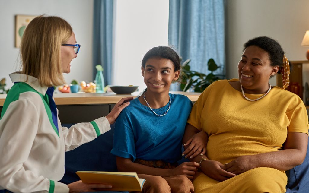 two ladies talking and smiling with a girl with special needs