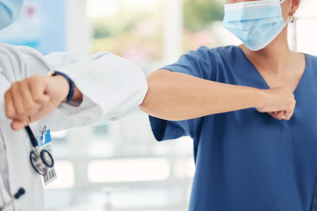 care professionals bumping elbows in greeting manner