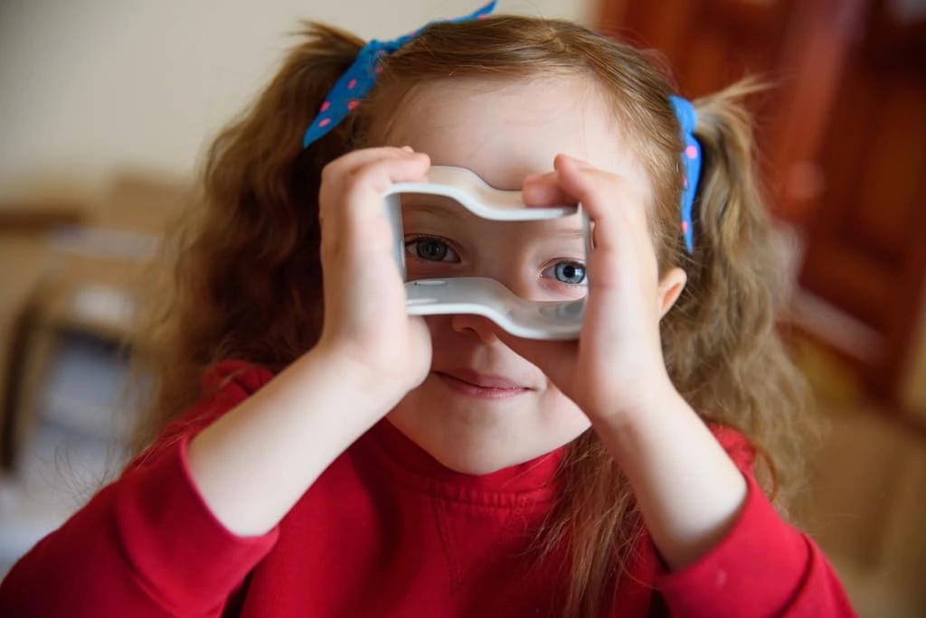 little girl looking through a prism